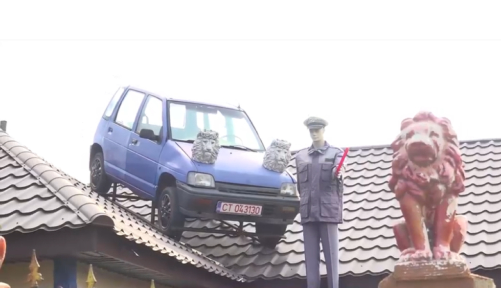 Un bărbat din Constanța a pus o mașină pe acoperișul casei sale. Lângă autoturism se află și un manechin de polițist